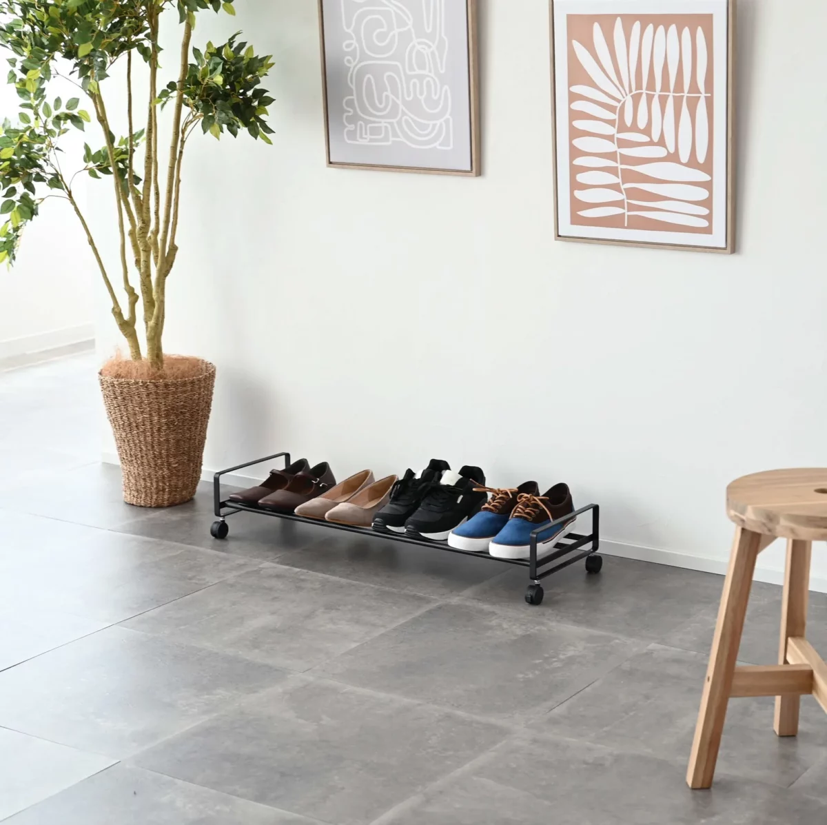 Yamazaki Schuhregal TOWER mit Rollen in Schwarz, weite Ansicht im Eingang unter Bildern und Pflanze