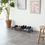 Yamazaki Schuhregal TOWER mit Rollen in Schwarz, weite Ansicht im Eingang unter Bildern und Pflanze