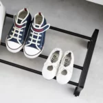 Yamazaki Schuhregal TOWER mit Rollen in Schwarz, Nahaufnahme mit Kinderschuhen auf den Streben