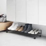 Yamazaki Schuhregal TOWER mit Rollen in Schwarz, unter dem Eingangsschrank mit Stiefeletten
