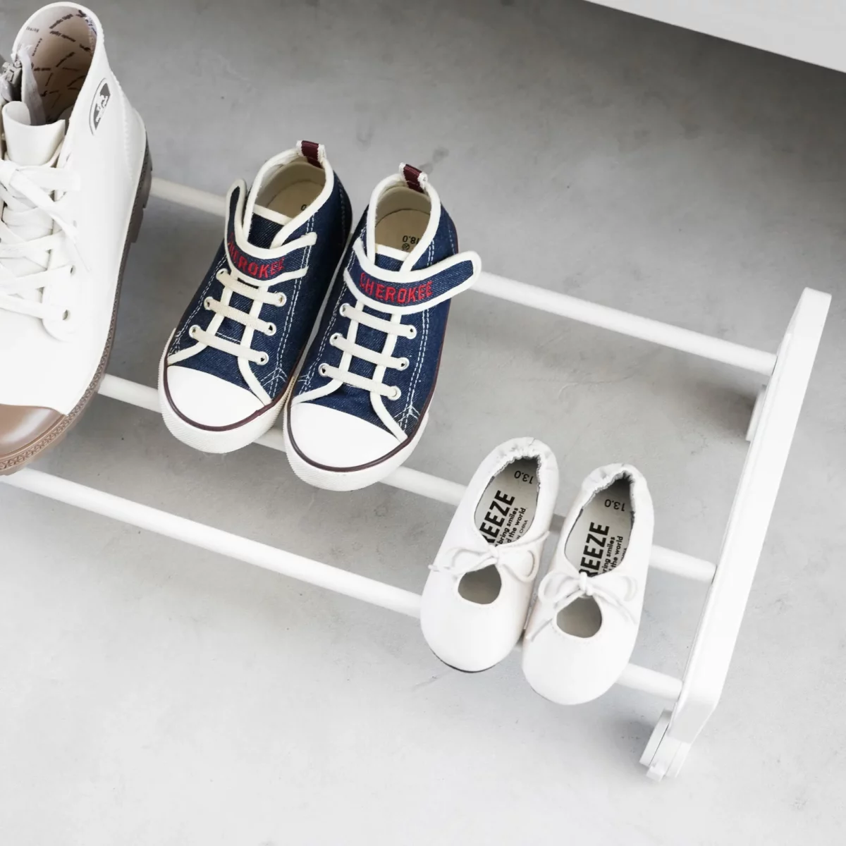 Yamazaki Schuhregal TOWER mit Rollen in Weiss, Nahaufnahme mit Kinderschuhen auf den Streben