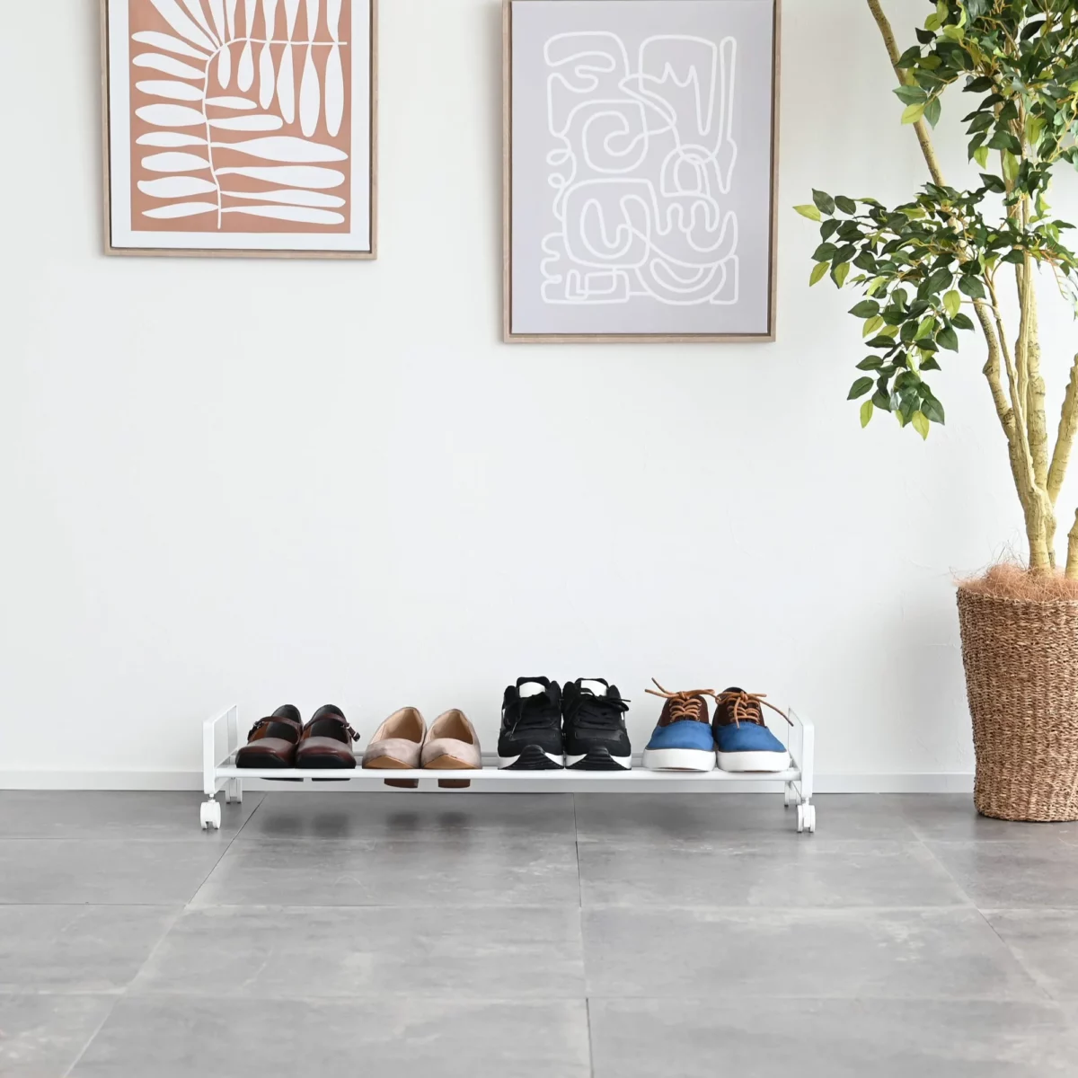 Yamazaki Schuhregal TOWER mit Rollen in Weiss, von vorne mit Schuhreihe vor weisser Wand