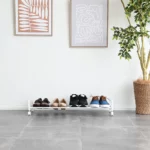 Yamazaki Schuhregal TOWER mit Rollen in Weiss, von vorne mit Schuhreihe vor weisser Wand