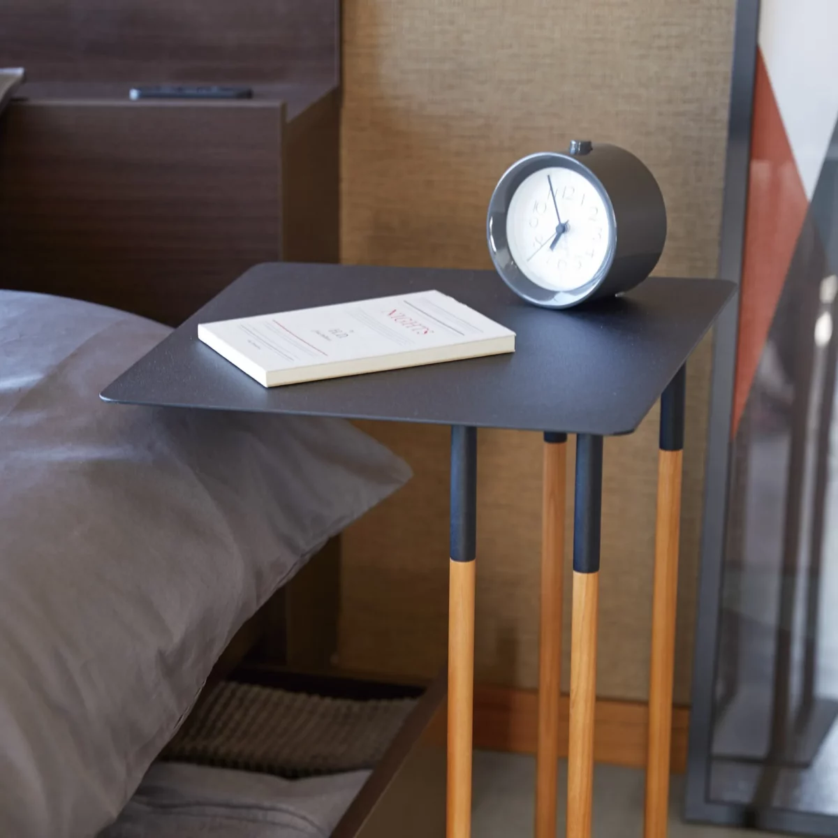 Table basse PLAIN de Yamazaki en noir, le plateau dépasse du matelas, gros plan
