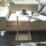 Table basse Yamazaki PLAIN en blanc, vue de face devant le canapé, avec une tasse à café posée sur le plateau