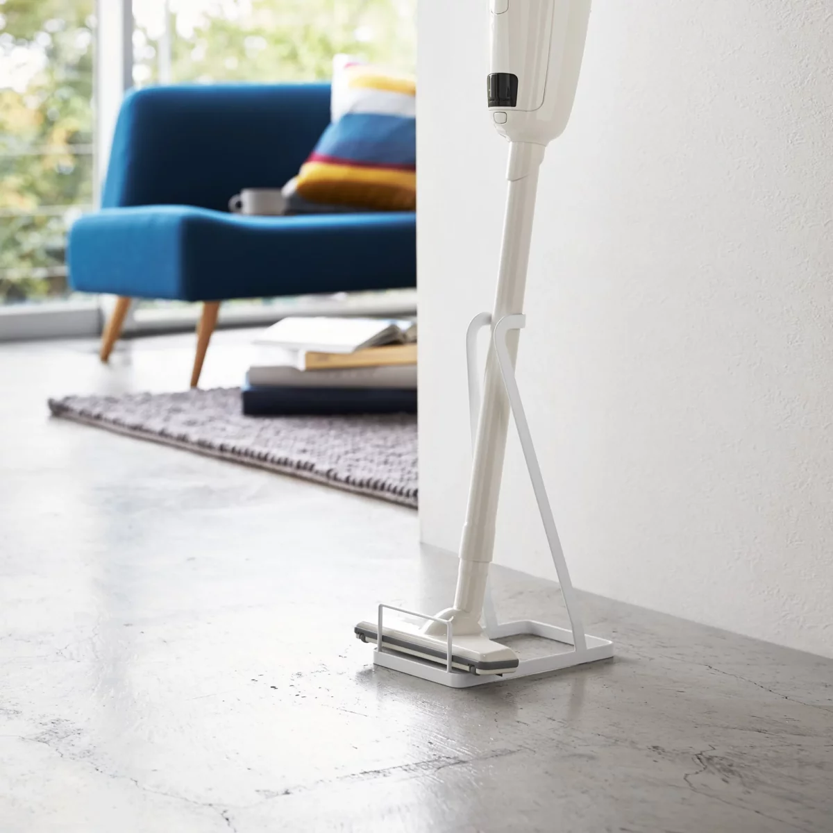 Yamazaki Staubsaugerständer TOWER in Weiss, mit Stielstaubsauger im Wohnzimmer neben dem Sofa