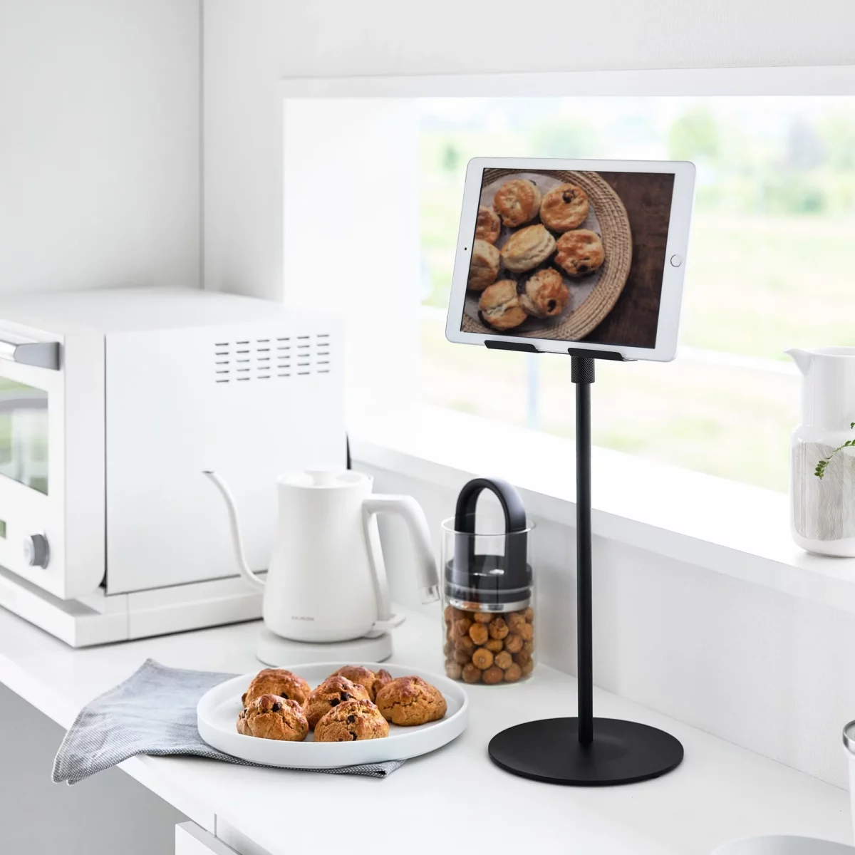 Support pour tablette Yamazaki SMART, réglable en hauteur, noir, dans la cuisine avec une recette affichée sur la tablette
