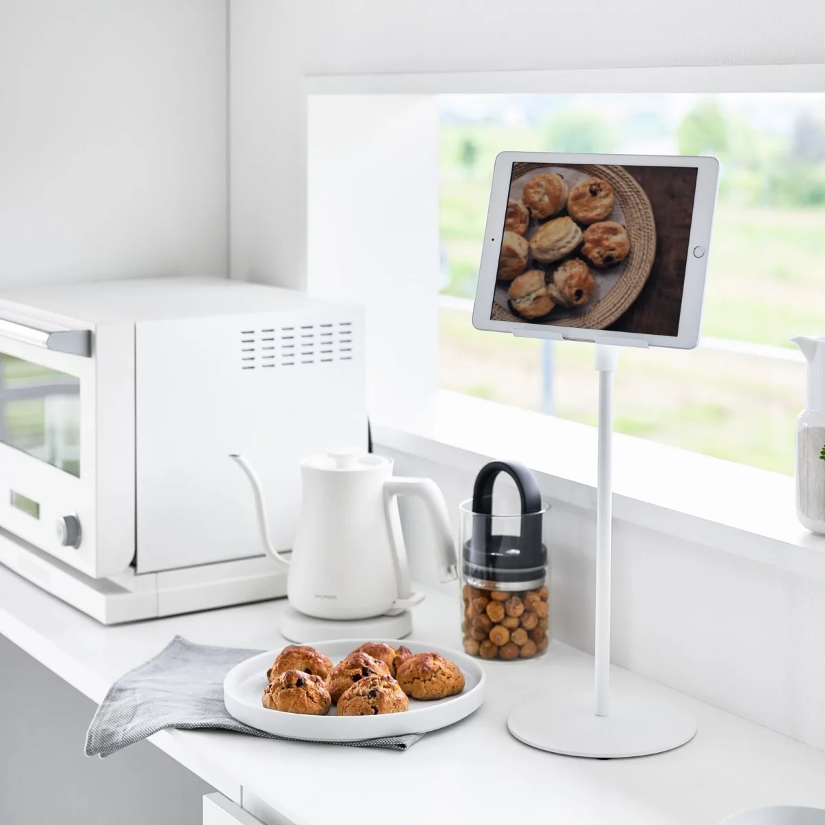 Support pour tablette Yamazaki SMART, réglable en hauteur, blanc, dans la cuisine avec une recette affichée sur la tablette
