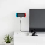 Support pour tablette Yamazaki SMART, réglable en hauteur, de couleur blanche, avec console de jeux posée sur le buffet pendant la recharge