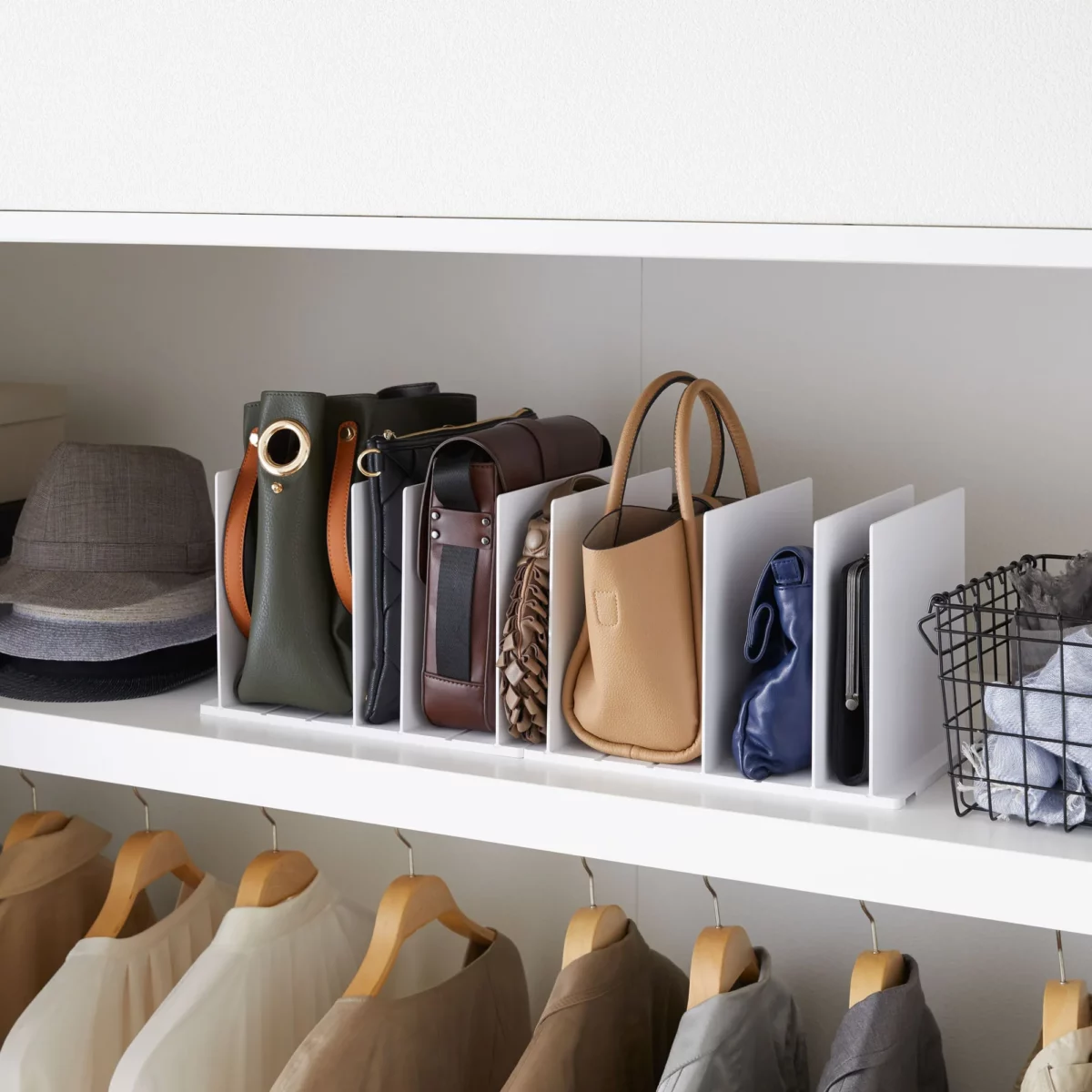 Lot de 2 organiseurs de poches Yamazaki TOWER, couleur blanche, sur l'étagère de l'armoire, à côté du chapeau et du panier en fil de fer