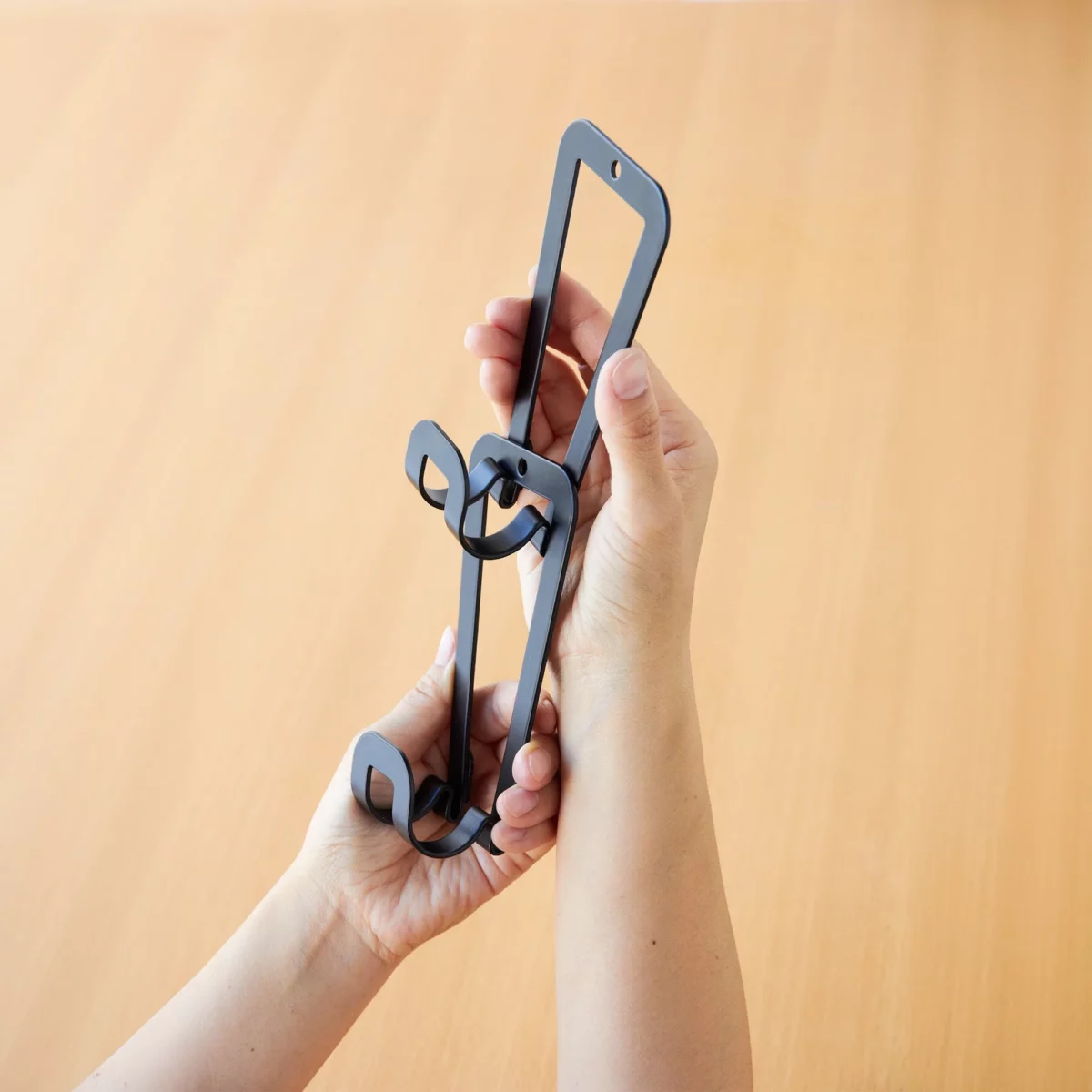 Yamazaki CHAIN S Bag Holder for Hanging, Black; hands connecting two links of the chain
