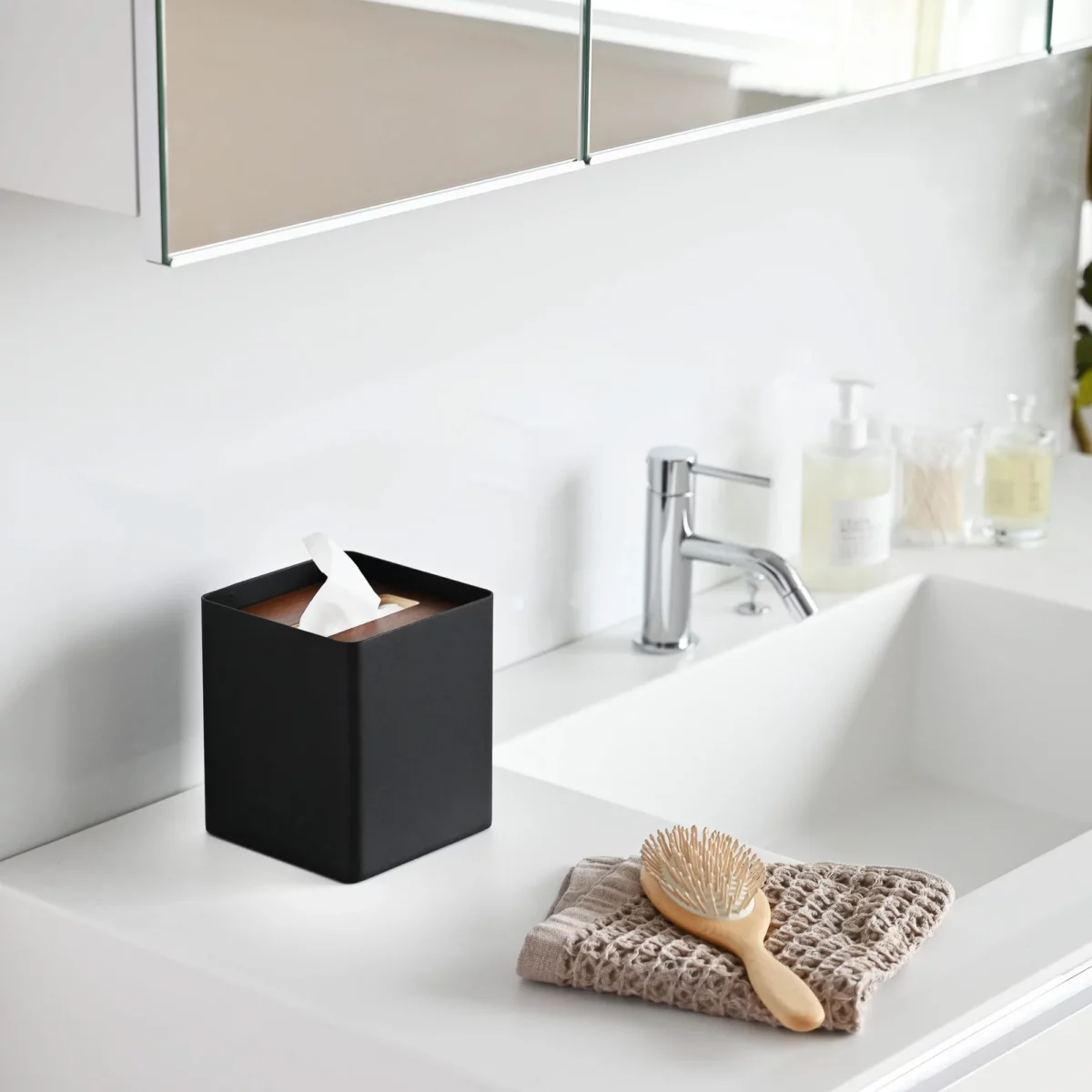 Yamazaki RIN Square Tissue Box in Black, on the bathroom sink next to the hairbrush