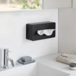Boîte à mouchoirs Yamazaki TOWER avec crochets adhésifs, de couleur noire, fixée au mur de la salle de bains au-dessus du lavabo avec porte-savon