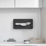 Boîte à mouchoirs Yamazaki TOWER avec crochets adhésifs, de couleur noire, fixée au mur sous l'armoire de toilette dans la salle de bains