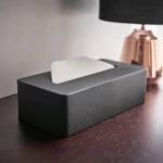 Yamazaki Taschentuchbox TOWER in Schwarz, auf dem dunklen Holztisch mit Taschentuch