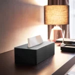 Yamazaki Taschentuchbox TOWER in Schwarz, auf dem Schreibtisch neben einer Tischleuchte