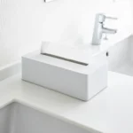 Yamazaki Taschentuchbox TOWER in Weiss, auf dem weissen Waschtisch neben dem Wasserhahn