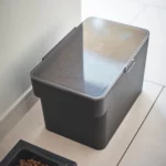 Yamazaki Tierfutterbehälter TOWER 6 l in Schwarz, schräg von oben mit Trockenfutter unter dem Deckel