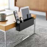 Yamazaki TOWER Narrow Table Clamp Basket in Black, on the coffee table with a remote control and tablet