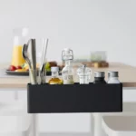 Yamazaki TOWER Narrow Table-Clamp Basket in Black, seen from the front at the breakfast table with cutlery and juice
