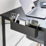 Yamazaki TOWER Narrow Table Clamp Basket in Black, on a desk with scissors, a notepad, and a smartphone
