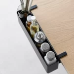 Yamazaki TOWER Narrow Table-Clamp Basket in Black, shown from above along the edge of the table with spice jars