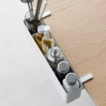 Yamazaki TOWER Narrow Table Clamp Basket in White, viewed from above along the edge of the table with spice jars