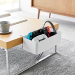 Yamazaki Tisch-Klemmkorb TOWER in Weiss, am Couchtisch mit Spielkonsole, Controller und Kopfhörer