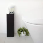 Porte-papier toilette Yamazaki TOWER, modèle étroit, noir, placé à côté des toilettes, avec des cotons-tiges sur la tablette