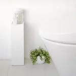 Porte-papier hygiénique Yamazaki TOWER, modèle étroit, blanc, placé à côté des toilettes, avec des cotons-tiges sur la tablette