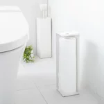 Porte-papier hygiénique Yamazaki TOWER, modèle étroit, blanc, placé de face à côté des toilettes avec les rouleaux visibles