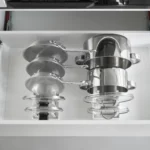 Organiseur de casseroles et de couvercles Yamazaki « TOWER », réglable, blanc, vu d'en haut avec des casseroles empilées dans le tiroir