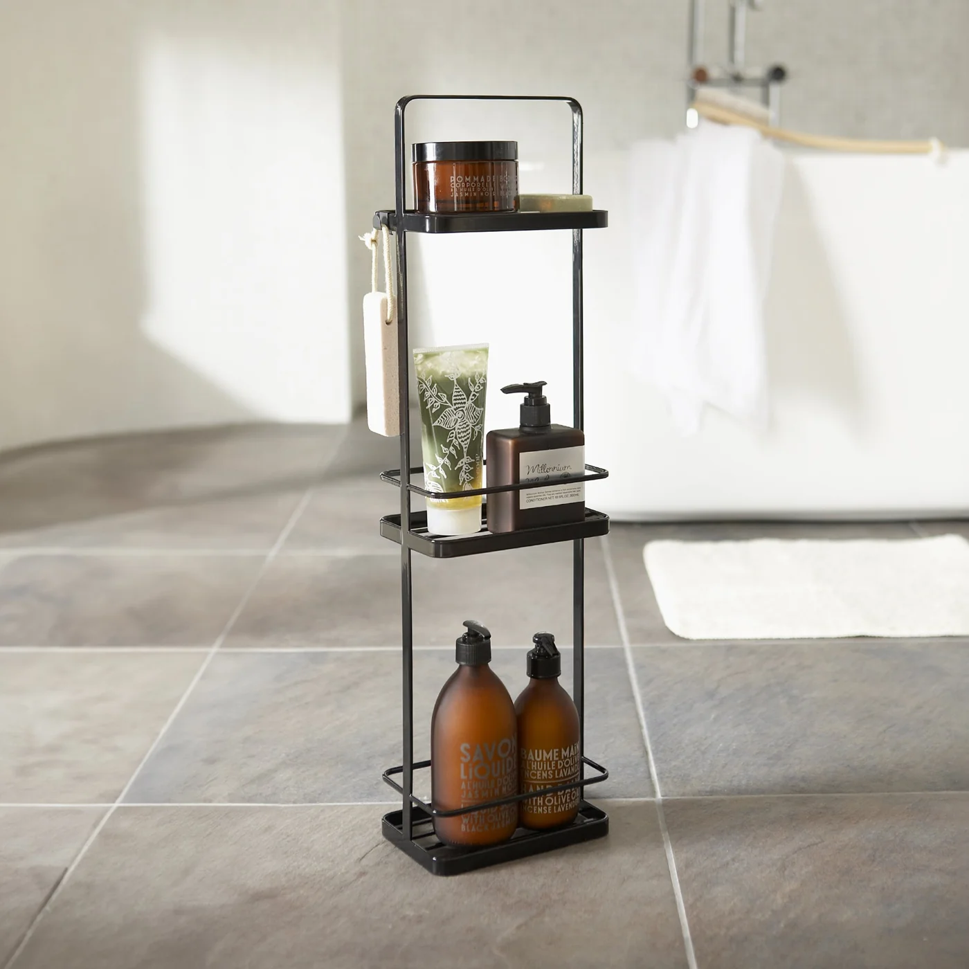 Schmales Yamazaki TOWER Badregal in Schwarz mit Shampoo und Seife im Badezimmer