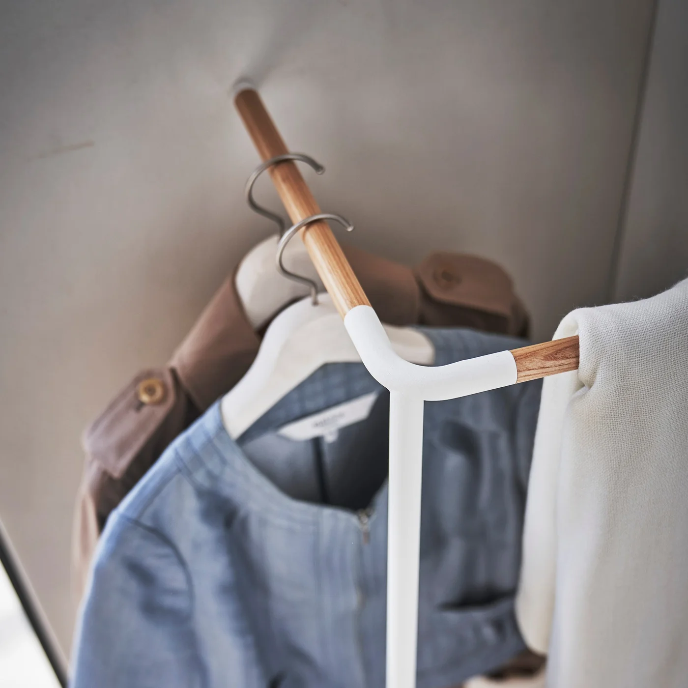 Yamazaki TOWER Garderobe CORNER in einer Raumecke mit Jeansjacke und Schal