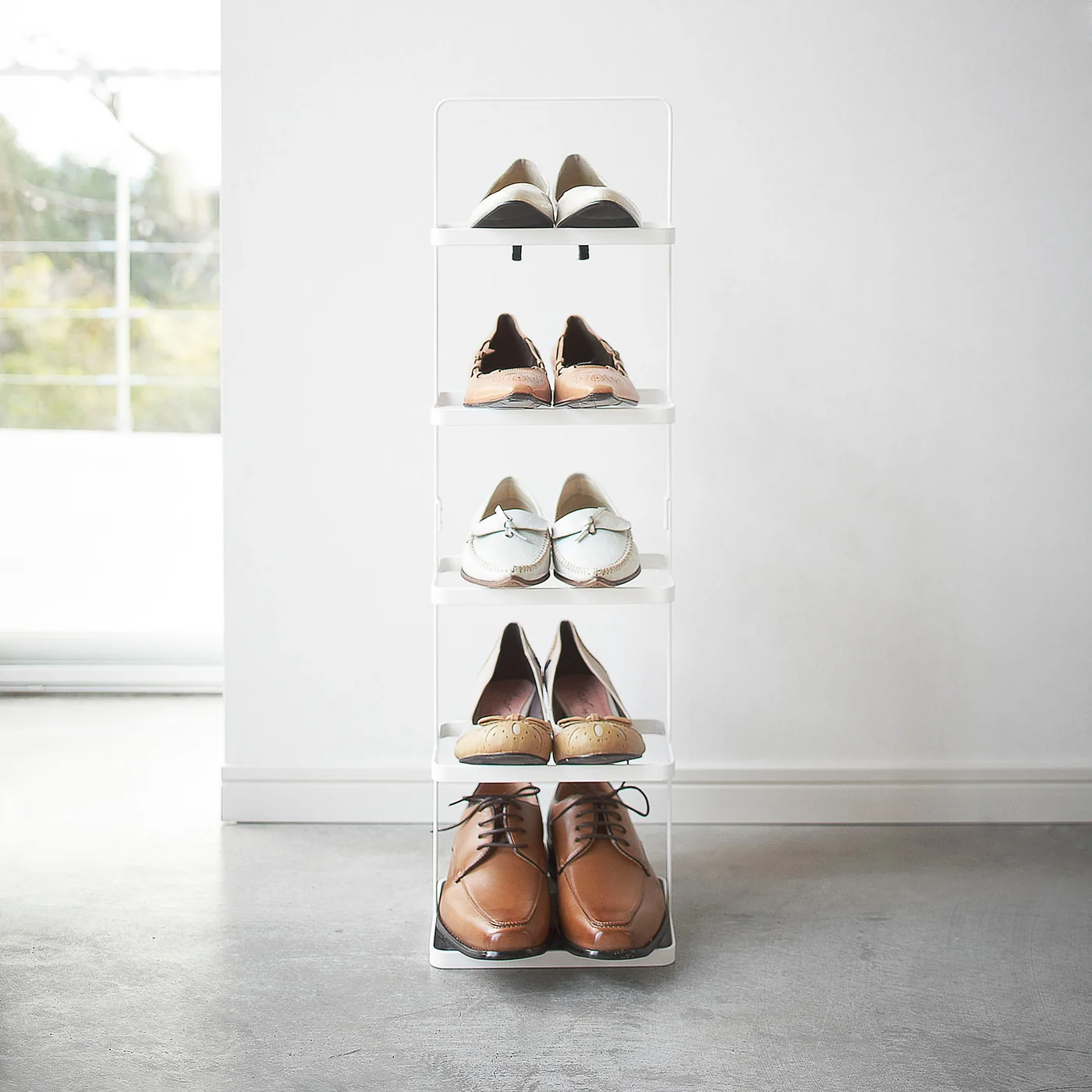 Hohes Yamazaki TOWER Schuhregal in Weiss mit sechs Paar Schuhen im Eingangsbereich