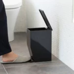 Yamazaki Treteimer TOWER fürs Bad in Schwarz, Fuss tritt auf das Pedal, der Deckel öffnet sich