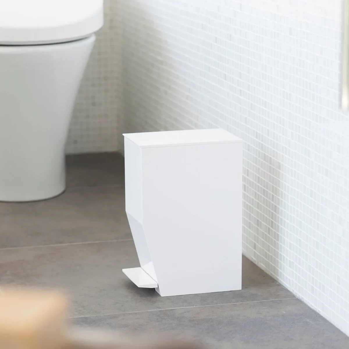 Yamazaki Treteimer TOWER fürs Bad in Weiss, auf dem Fliesenboden neben der Toilette