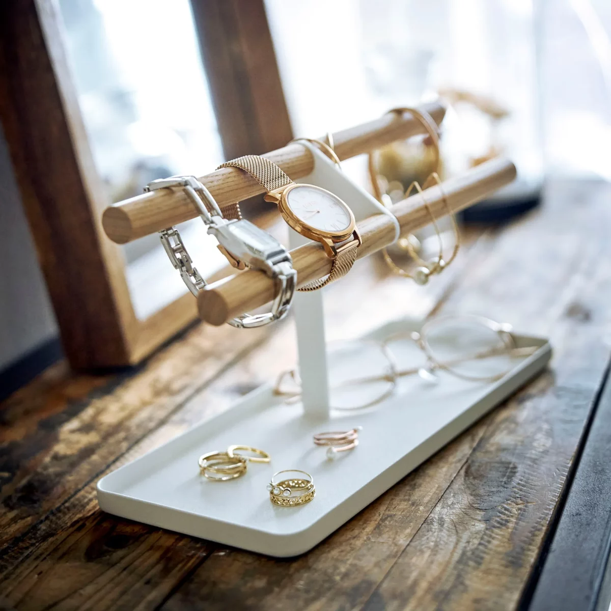 Yamazaki Uhrenständer TOSCA mit Holzstäben in Weiss, vor dem Spiegel mit Uhren und Ringen