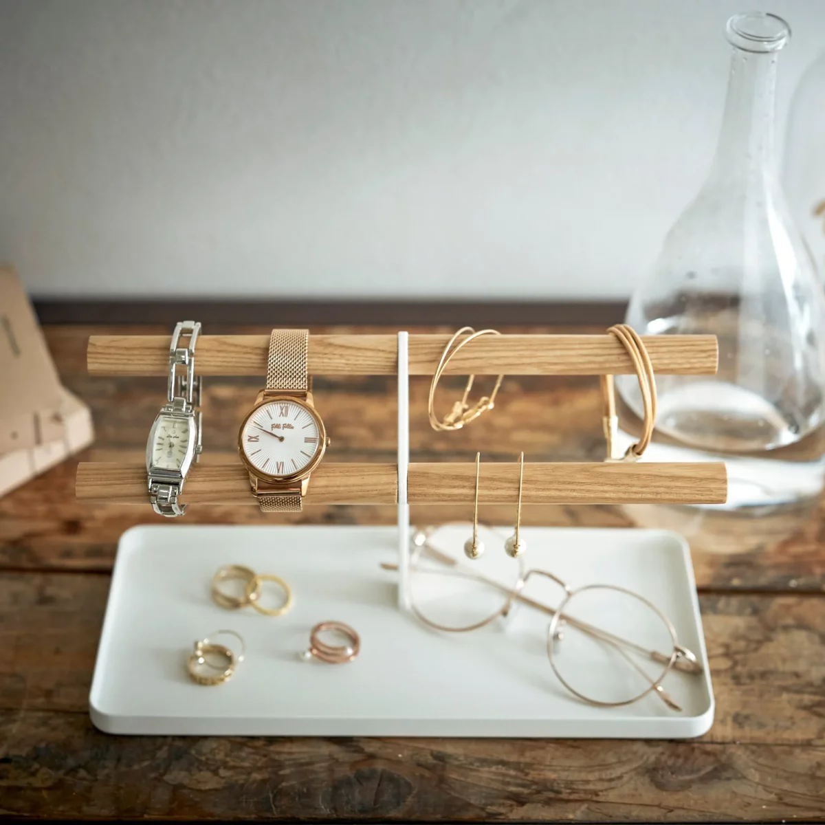 Yamazaki Uhrenständer TOSCA mit Holzstäben in Weiss, von vorne mit Uhren, Ringen und Brille in der Schale