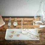 Yamazaki Uhrenständer TOSCA mit Holzstäben in Weiss, von vorne mit Uhren, Ringen und Brille in der Schale