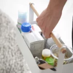 Yamazaki Utensilienbox TOSCA gross in Weiss, eine Hand trägt die gefüllte Box am Holzgriff