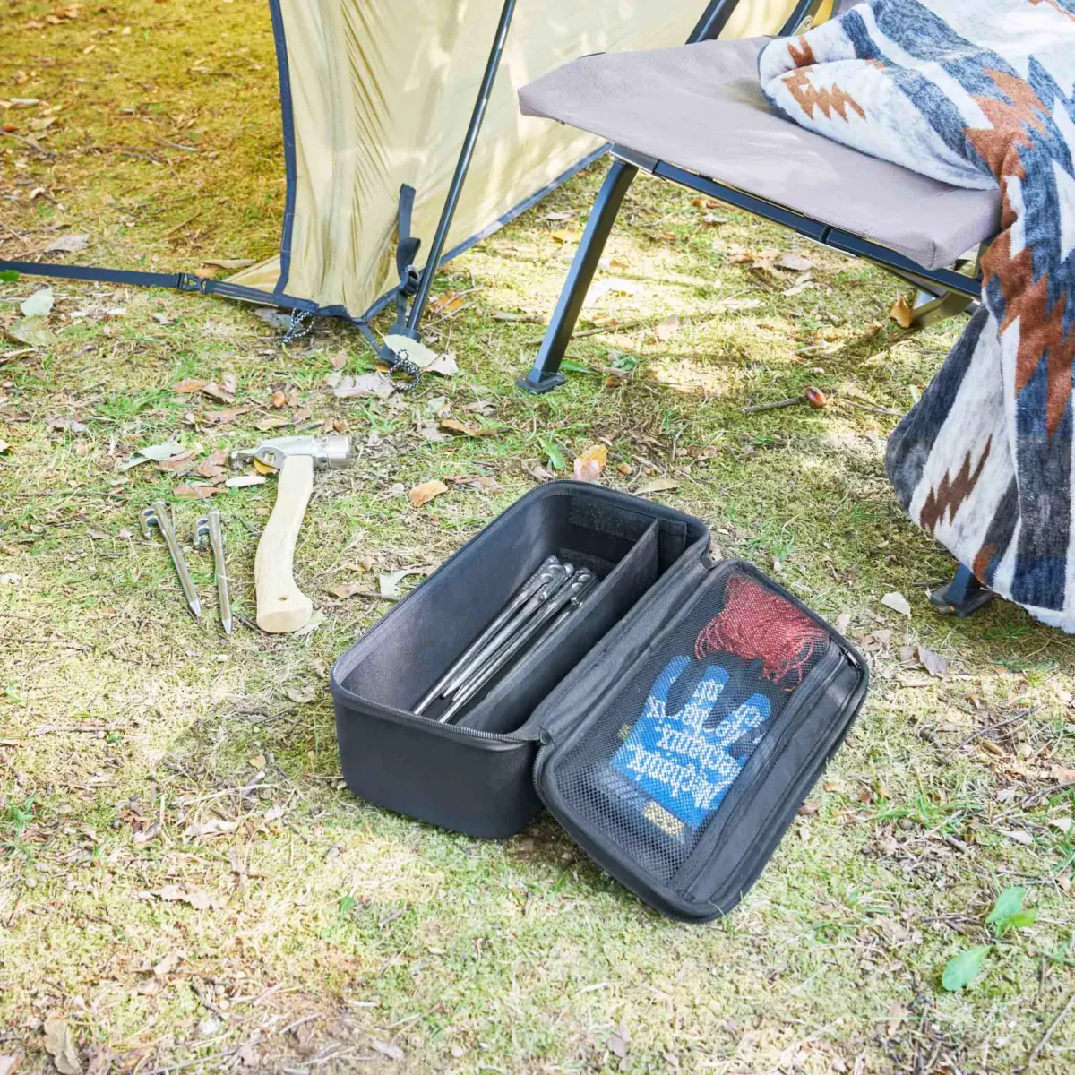Yamazaki Werkzeugtasche TOWER mit Trennwand in Schwarz, offen auf der Wiese beim Camping mit Heringen