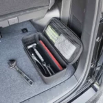 Yamazaki Werkzeugtasche TOWER mit Trennwand in Schwarz, offen im Kofferraum mit Werkzeug und Warnweste