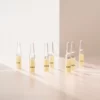 Mehrere BABOR Active Purifier Ampullen stehend im warmen Licht auf heller Fläche, Lifestyle-Foto