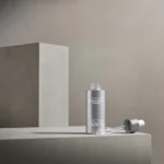 BABOR Derma Filler Serum mit herausgezogener Pipette auf grauen Steinquadern, Stimmungsbild in Grau