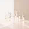 Mehrere BABOR SOS Calming Ampullen stehend im warmen Licht auf heller Fläche, Lifestyle-Foto