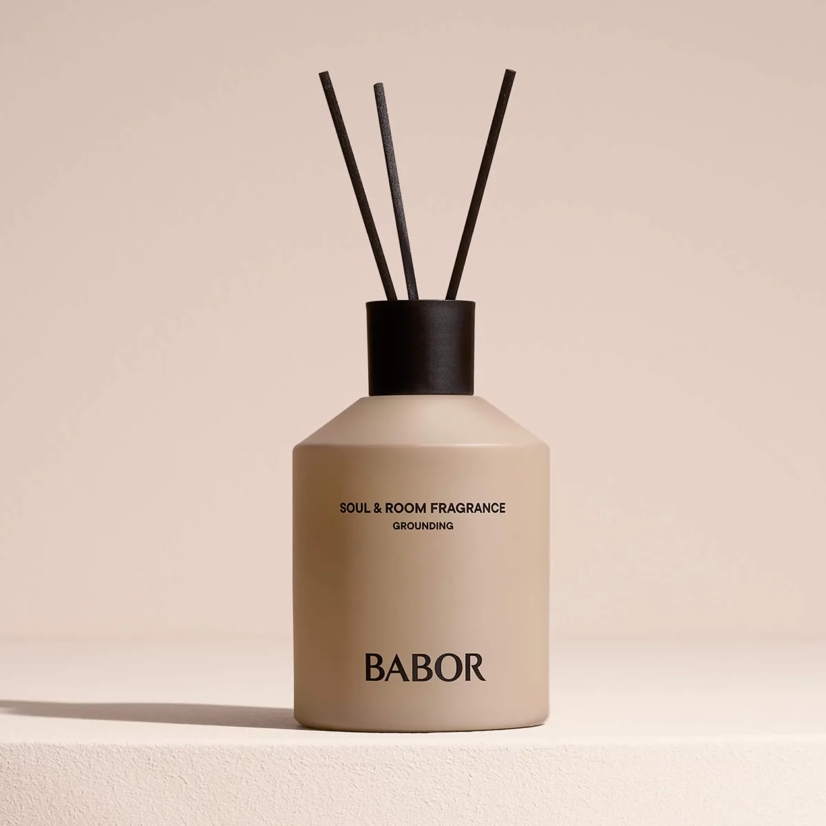 BABOR Soul & Room Fragrance Grounding mit Duftstäbchen auf hellem Sockel vor beigem Hintergrund