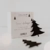 Verpackung des Eulenschnitt Holzanhänger Tanne 8er-Set in Schwarz mit Angabe 6 x 5 cm, davor zwei schwarze Tannen