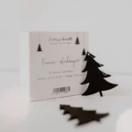 Packaging for the Eulenschnitt wooden fir tree pendants (set of 8) in black, labeled 6 x 5 cm, with two black fir trees in the foreground