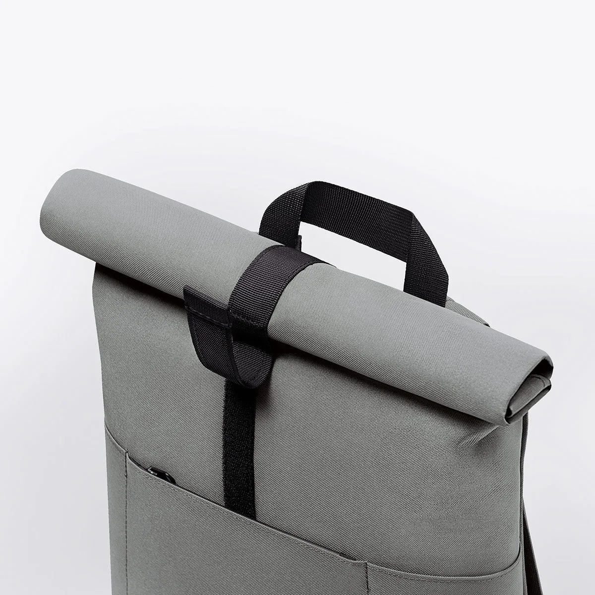 Gros plan du rolltop enroulé du sac Ucon Acrobatics Hajo Medium Stealth gris, avec patte auto-agrippante et poignée